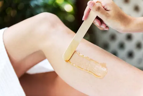 Woman waxing her legs